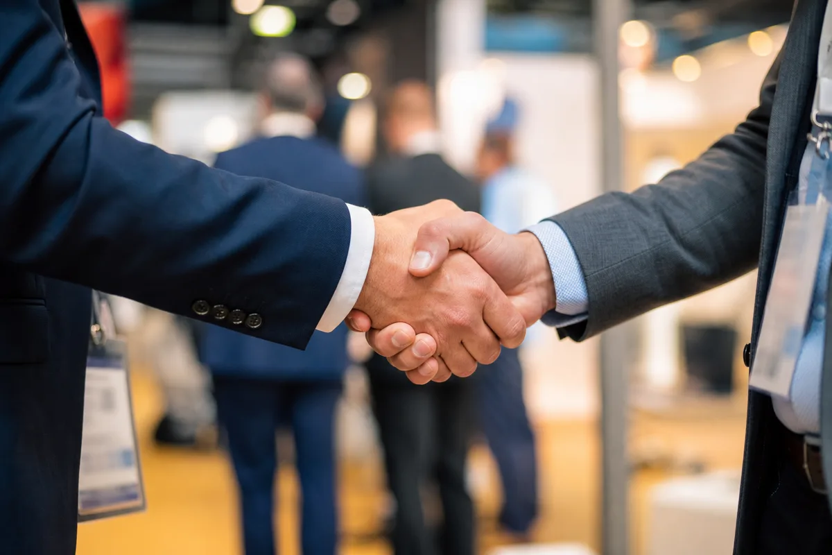 Deux mains se serrant lors d&rsquo;un moment d&rsquo;échange professionnel dans un salon