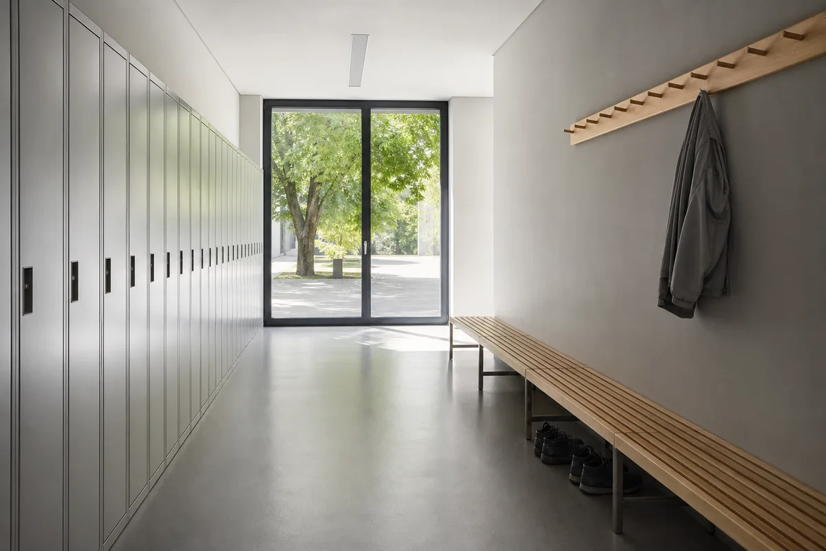 Couloir de centre de formation avec banc en bois et vestiaires aux portes lisses